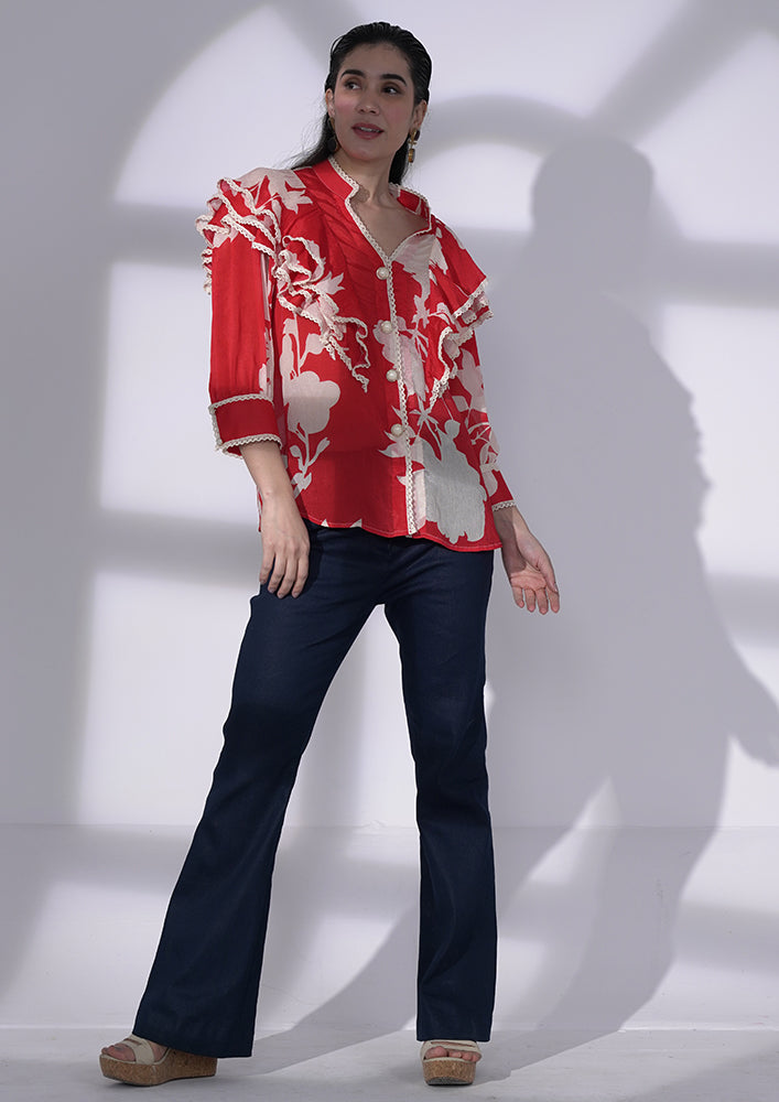 Red and white floral-printed chiffon ruffle shirt with lace and pearl buttons. IKI CHIC Private Ltd.