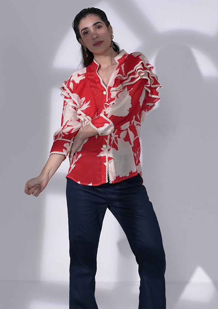 Red and white floral-printed chiffon ruffle shirt with lace and pearl buttons. IKI CHIC Private Ltd.