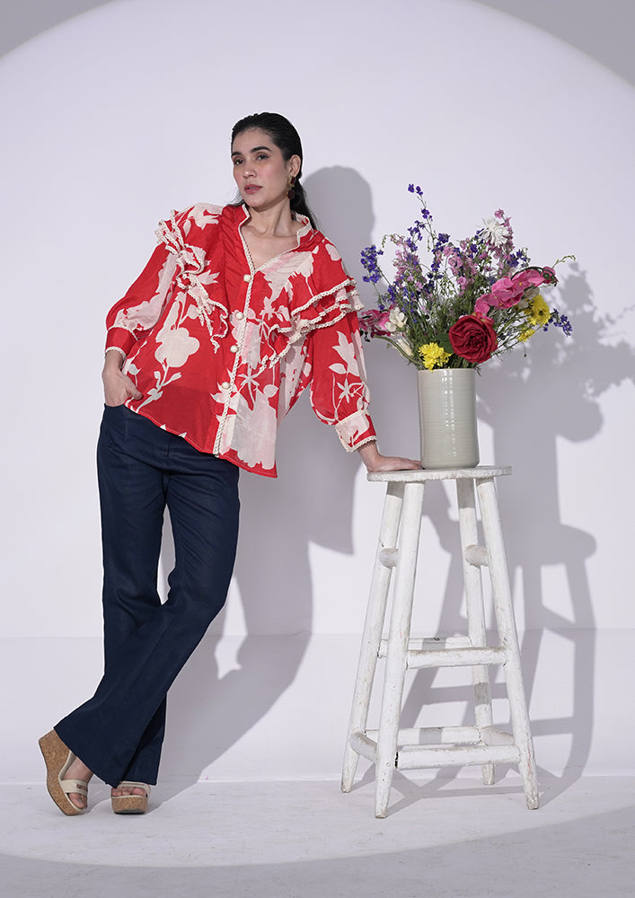 Red and white floral-printed chiffon ruffle shirt with lace and pearl buttons. IKI CHIC Private Ltd.