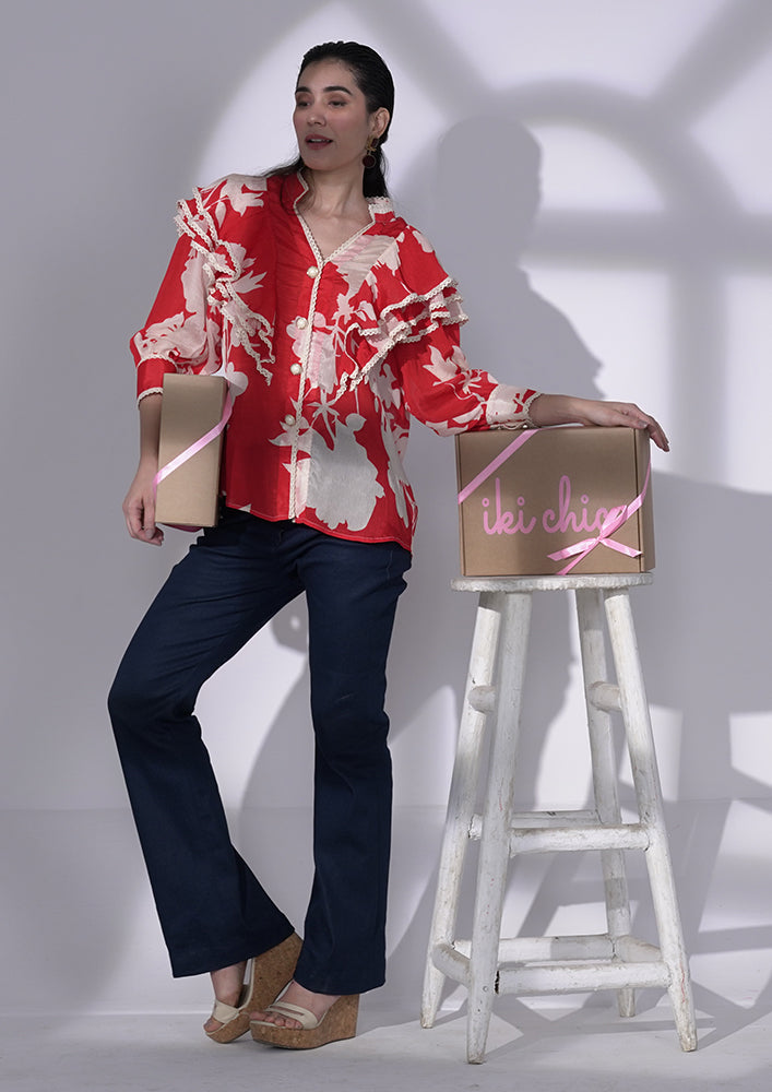 Red and white floral-printed chiffon ruffle shirt with lace and pearl buttons. IKI CHIC Private Ltd.