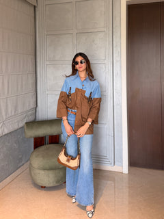 Woman in a stylish outfit with a striped shirt is standing indoors.